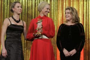 French actress Catherine Deneuve (R) smiles after presenting the