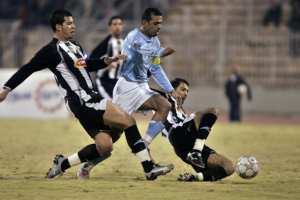 Hassouneh al-Sheikh (C) of Jordan's Al-Faisali is tackled by