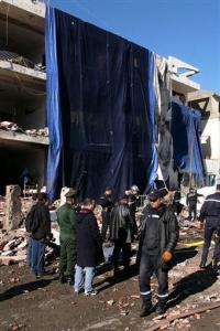 Rescuers and policemen work outside a seriously damaged building