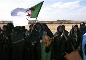 Touareg women waving the Algerian flag wait for Algeria's