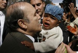 Algeria's President Abdelaziz Bouteflika kisses a baby during his