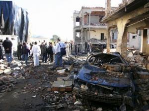 Residents look on at the scene of a car