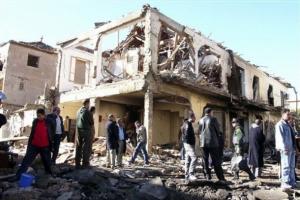 Residents look on at damaged buildings at the scene