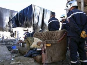 Rescuers work by the wreckage of a police station,
