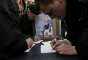 Bosnian Muslims sign a petition before a protest against