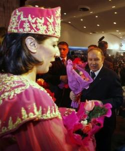 Algeria's President Abdelaziz Bouteflika (R) gives flowers to a
