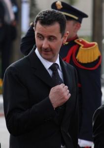 Syrian President Bashar al-Assad gestures during a welcoming ceremony