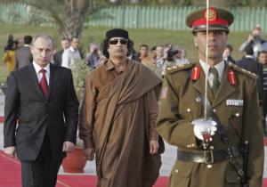 Russian President Vladimir Putin (L) and Libyan leader Moamer