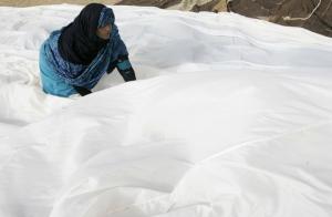 A Saharawi woman works on a traditional tent at