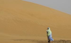 A Sahrawi woman walks on the sand dunes of