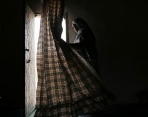 A Sahrawi woman stands at the doorway of her