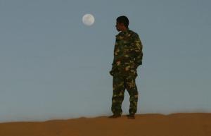 A Sahrawi man dressed in military clothes waits for