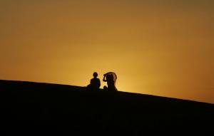 Spanish tourists watch the sun set at the Sahara