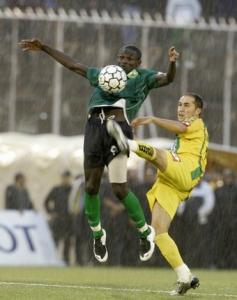 Karmiro Daouda of Cameroon's Coton Sport (L) fights for