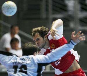 Vitaly Ivanov (R) of Russia shoots the ball over