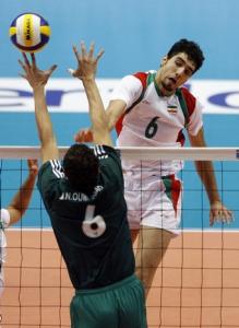 Iran's Seyed Mohammad Mousavi (R) spikes the ball past