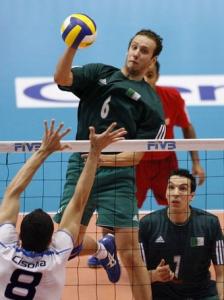 Algeria's Oumessad Mohamed Amine (C) spikes the ball against
