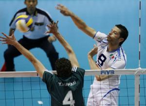 Italy's Alberto Cisolla (R) spikes the ball against Algeria's
