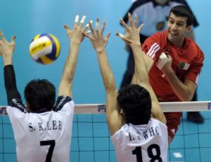 Algeria's Benhallal Rachid (R) spikes the ball past South