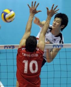 South Korea's Moon Sung-Min (R) spikes the ball past