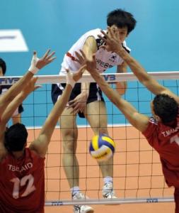 South Korea's Moon Sung-Min (C) spikes the ball past
