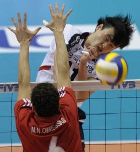 South Korea's Lee Kyung-Soo (R) spikes the ball past