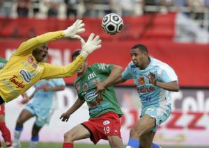 JSM Bejaia's goalkeeper Bilal Njeukam (L) stops a shot