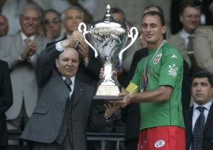 Algerian President Abdelaziz Bouteflika( L) presents the cup to