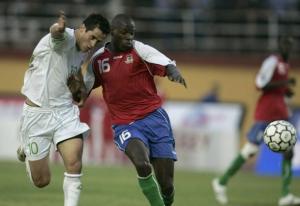 Algeria's Rafik Saifi (L) fights for the ball with