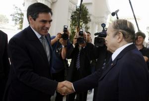 Algeria's President Abdelaziz Bouteflika (R) shakes hands with French