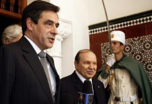 French Prime Minister Francois Fillon (L) answers journalists' questions