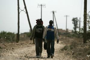 Would-be immigrants walk at the border between Morocco and