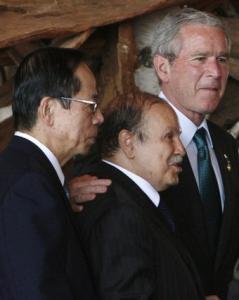 U.S. President George W. Bush (R) walks with President