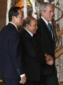 U.S. President George W. Bush (R) walks with