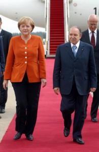 Algerian President Abdelaziz Bouteflika (R) walks with German Chancellor