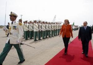 Algerian President Abdelaziz Bouteflika (R) walks with German Chancellor