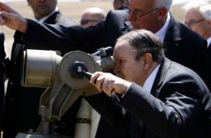 Algeria's President Abdelaziz Bouteflika looks through giant binoculars at