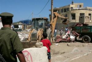 A child looks on as a mechanical shovel removes