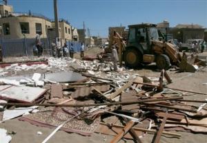 A mechanical shovel removes the debris, Sunday, Aug. 10,