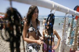 Girls look at handcrafts on the Little Paradise beach