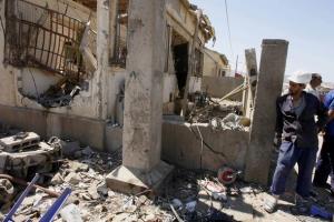 A municipal worker stands next to a damaged house