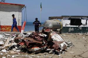 A civil defence worker stands next to a damaged
