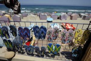 People enjoy the beach in beachhouses as flipflops for