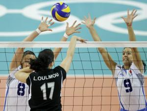 Lydia Oulmou of Algeria spikes against Jenny Barazza and