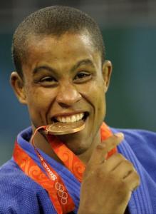 Switzerland's Sergei Aschwanden bites his bronze medal on the