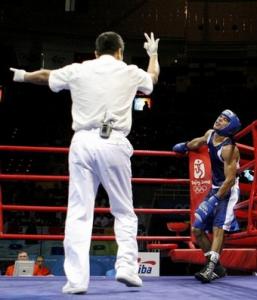A referee makes a standing count to Nabil Kassel