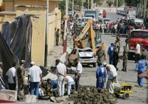 People investigate after two car bomb attacks took place