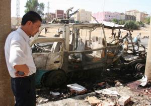 A man stands next to the remains of a