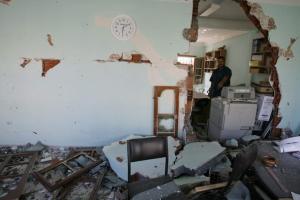 A Chamber Of Agriculture worker stands at his damaged