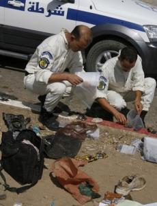 Bomb disposal experts collect evidence at the site of